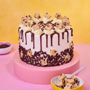 Cookie Dough Cake with edible cookie dough chunks, vanilla buttercream, chocolate chips, and chocolate ganache drip by Crumbs & Doilies